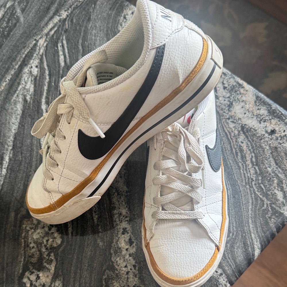 Nike Women's White Athletic Shoes with Gold and Black Details